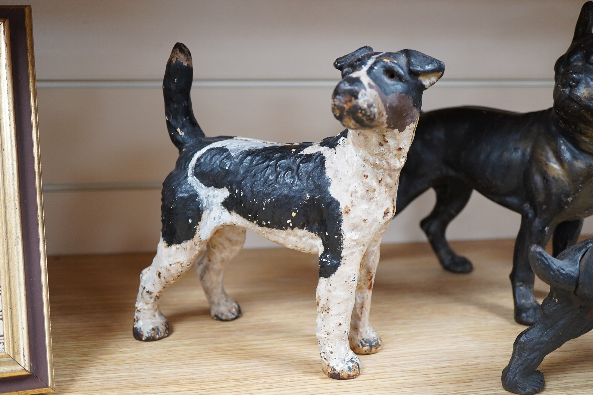 A group of three painted metal dogs, largest 25cm high x 23cm wide